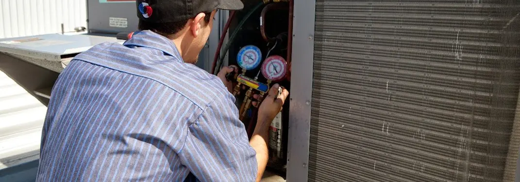 HVAC technician servicing a condenser unit in Meridian
